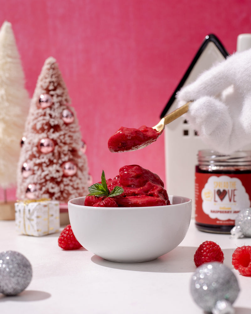 Raspberry Sorbet in a Christmas Background with hand scooping a spoonful 