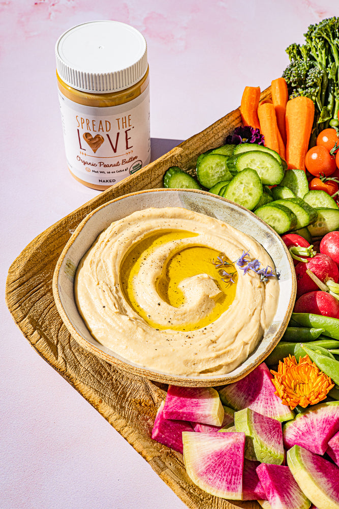 Veggie board with Savory Peanut Dip and a jar of Spread The Love Peanut Butter