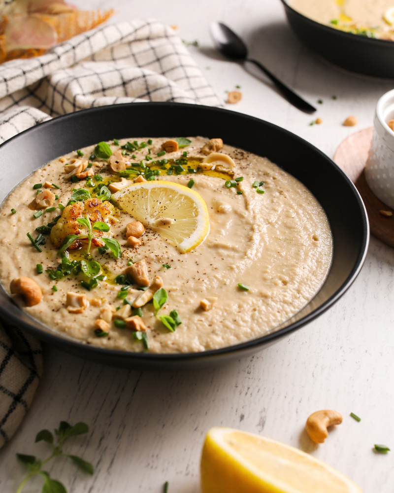 Bowl of Cashew Cauliflower Soup topped with lemon