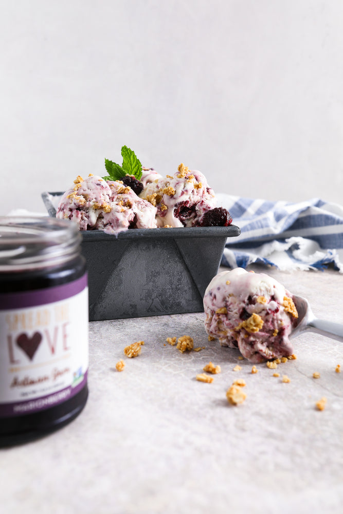 Bowl and scoop of Marionberry Crumble Ice Cream with a jar of Marionberry Jam