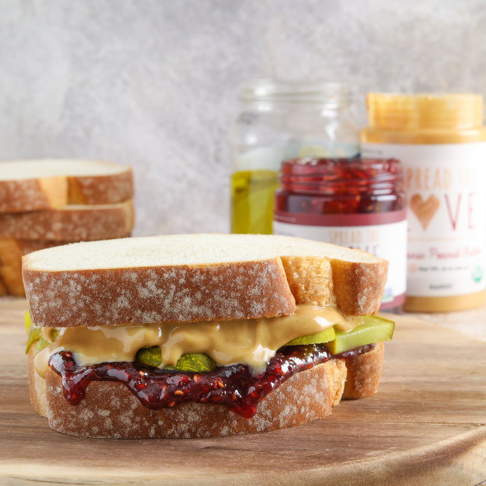 PB&J and pickle sandwich with Raspberry Jam, Peanut Butter and pickle jar in background