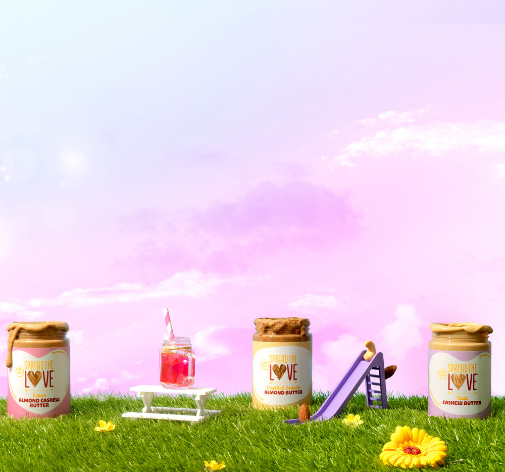3 nut butter jars on a grassy mini playground with pink and purple sky in the background