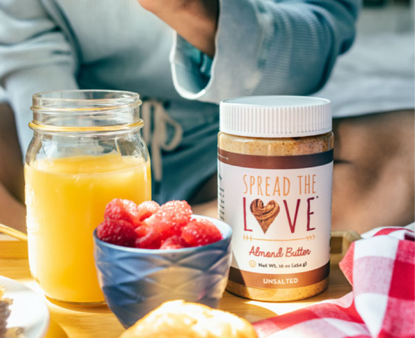 Morning breakfast of Spread The Love UNSALTED Almond Butter, orange juice and raspberries