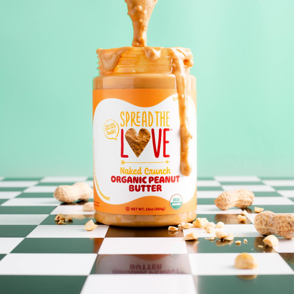 
                  
                    Load image into Gallery viewer, Spread The Love Naked Crunch Peanut Butter Jar with spoon drizzling peanut butter into jar
                  
                