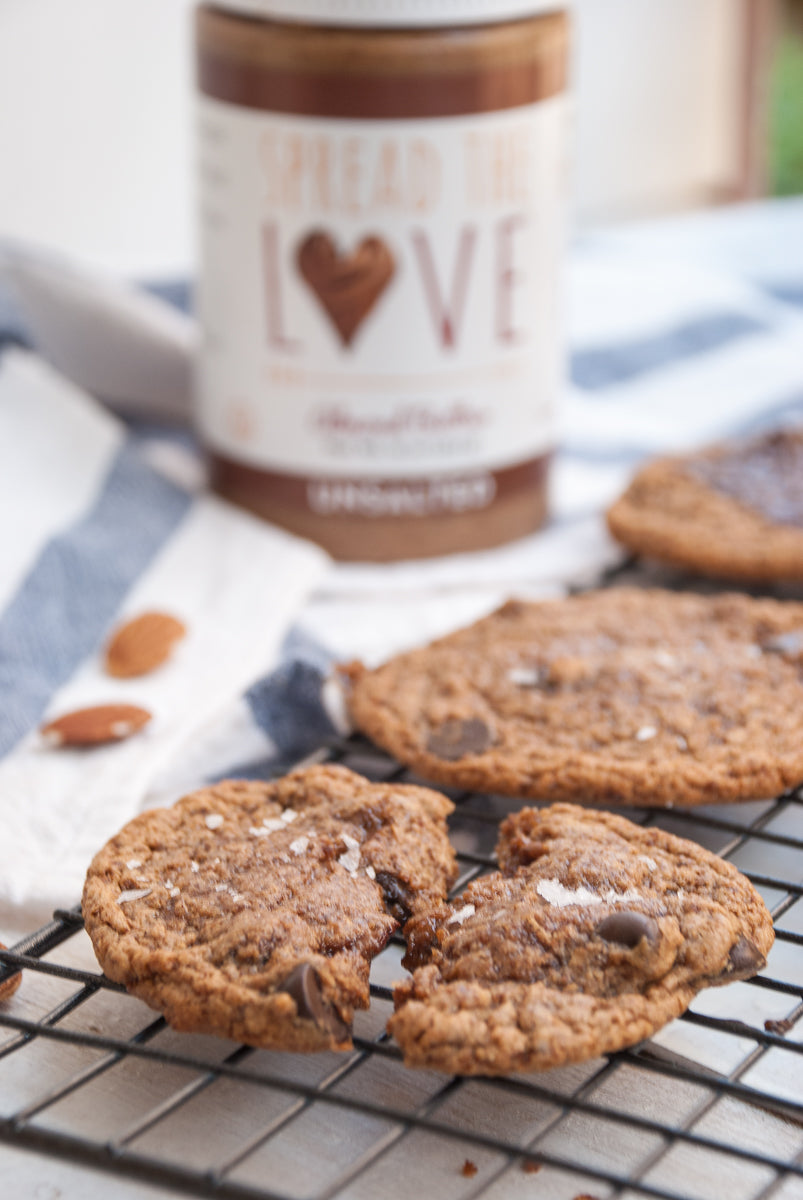 Almond Butter Cookies on a cooling rack with Spread The Love Almond Butter in the background
