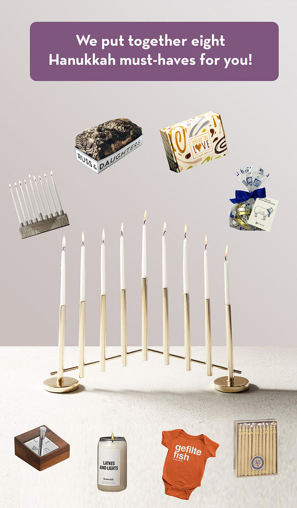 Menorah with candles, dreidel, gelt, challah, gifts, guidebook.
