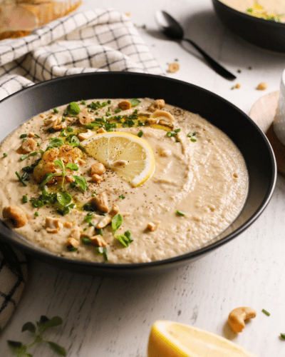 Bowl of Cashew Cauliflower Soup topped with lemon