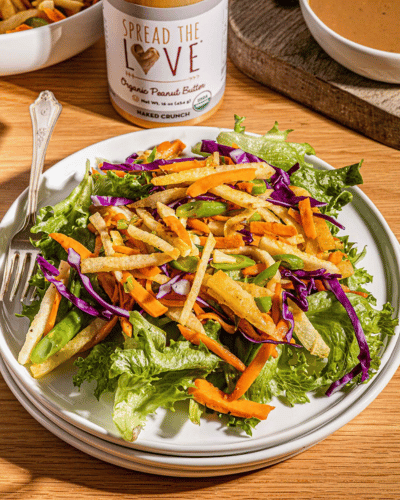 Plate of fresh lumpia salad with Spread The Love NAKED CRUNCH Peanut Butter jar