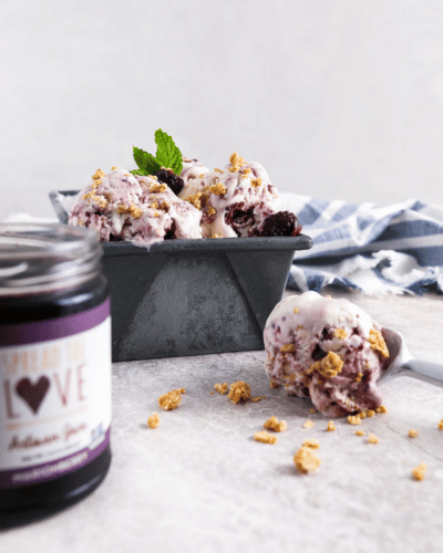Bowl and scoop of Marionberry Crumble Ice Cream with a jar of Marionberry Jam