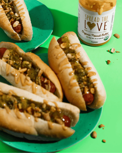 Plate full of Hot Dogs with relish and peanut butter drizzle 