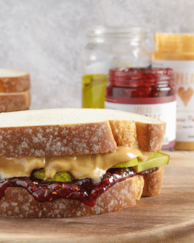 PB&J and pickle sandwich with Raspberry Jam, Peanut Butter and pickle jar in background
