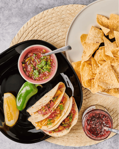 Plate of Raspberry Jam Taco with Sauce and jar of Raspberry Jam and a plate of chips