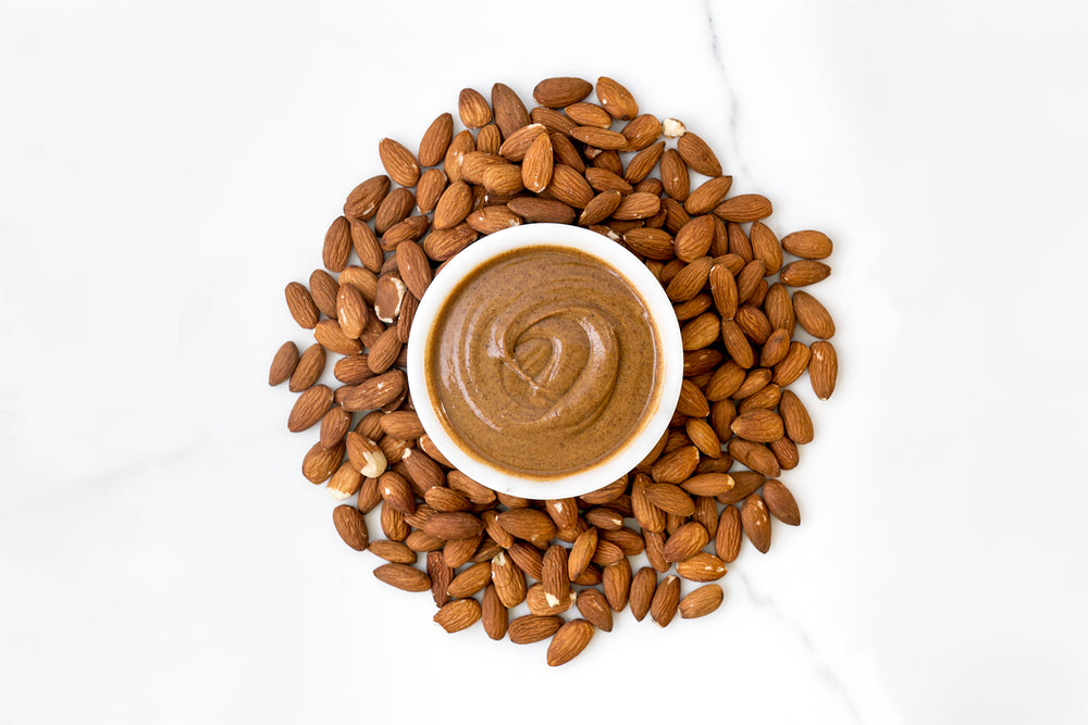 Bowl of Almond Butter surrounded by Almonds