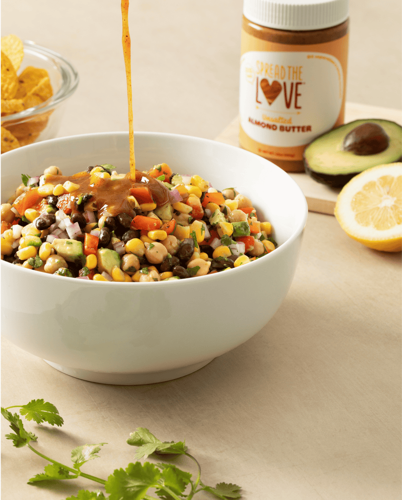 Almond Butter Bean Salad in a bowl with dressing being drizzled
