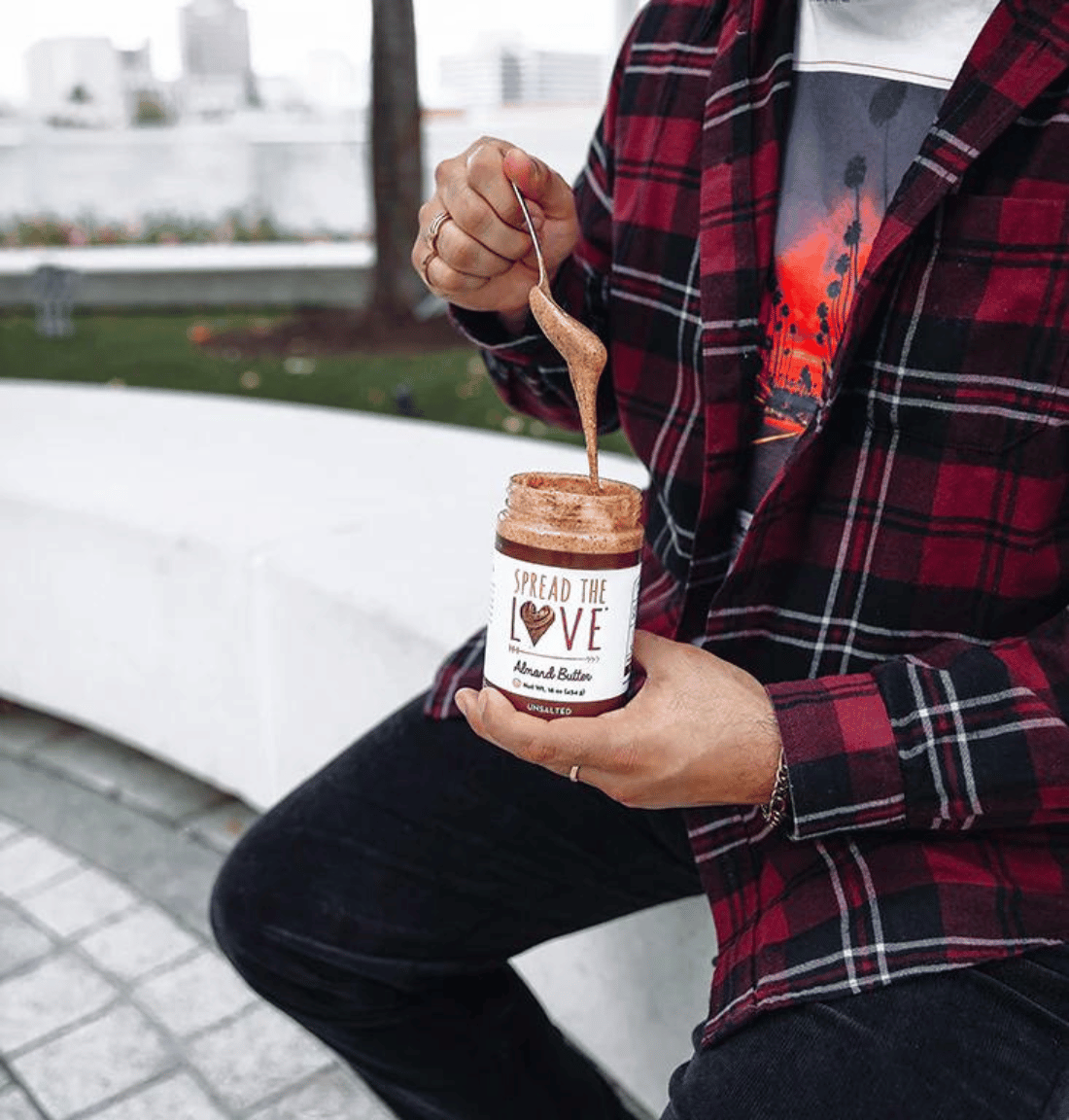Photo of someone with spoon drizzling Spread The Love Unsalted Almond Butter.