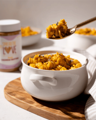 Bowl with Pumpkin Cashew Pasta and spoon scooping pasta