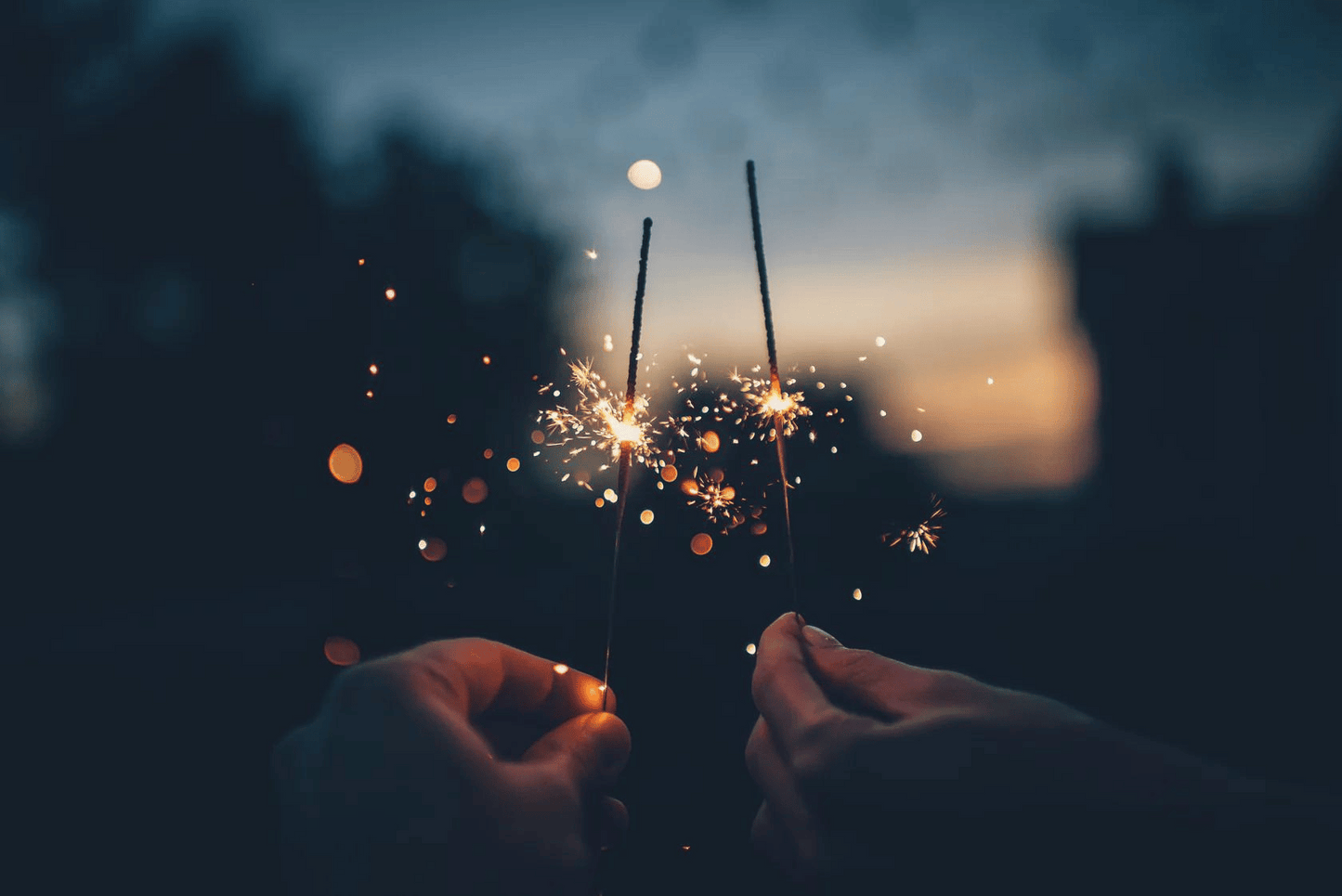 Photo of two people holding sparklers in their hands