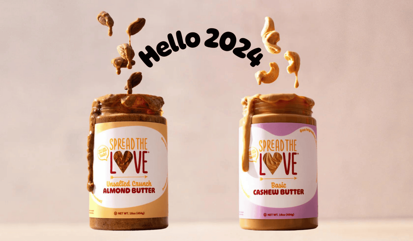 Jar of Unsalted Crunch Almond Butter with almonds floating on top of jar next to Basic Cashew Butter with cashews floating on top of jar. Words "Hello 2024" are placed in between the floating.