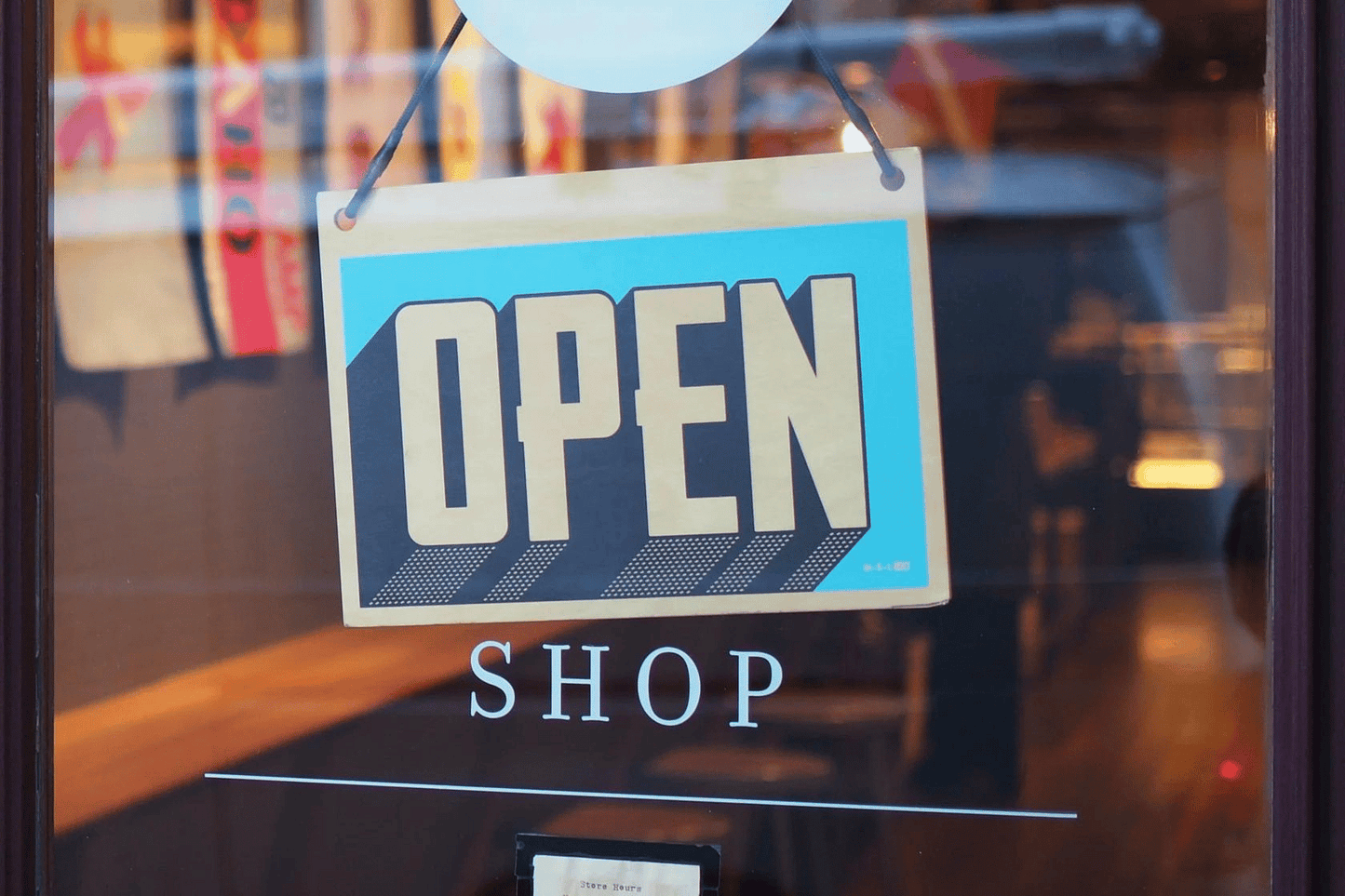 Photo of a store with an open sign on the door.