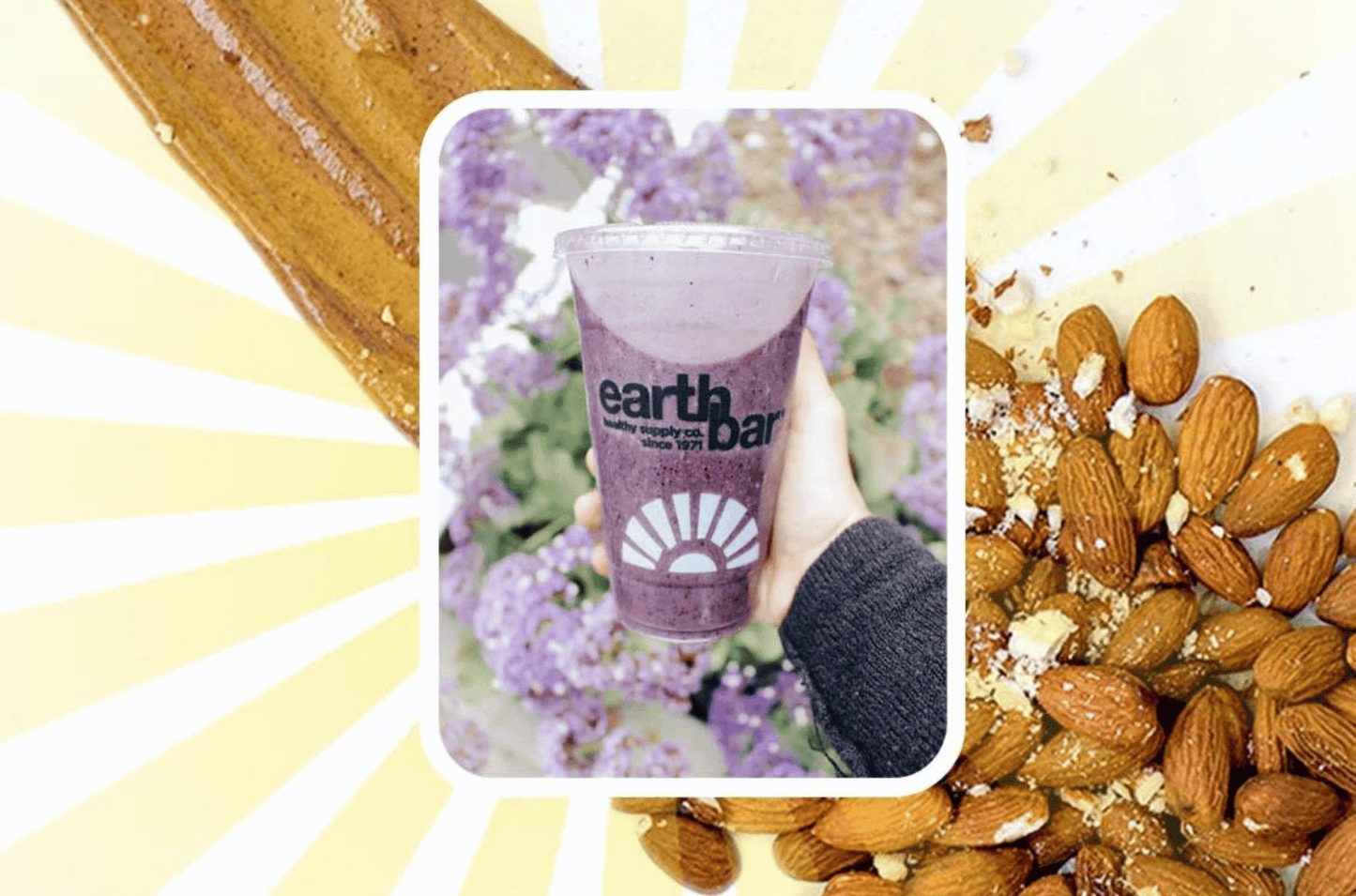 Hand holding a smoothie from Earth Bar with almonds and spread.