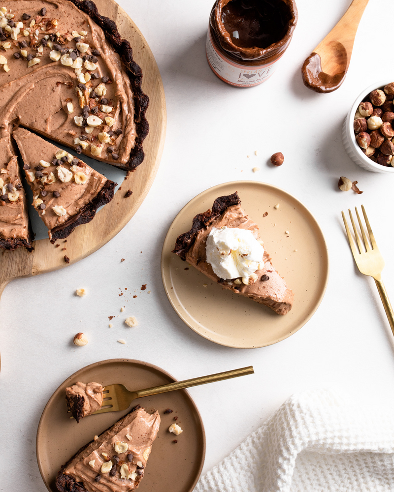 Brownie Crusted Chocolate Hazelnut Pie with slices of pie and a jar of Chocolate Hazelnut Dessert Butter 