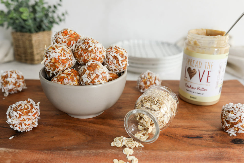 Bowl of Carrot Cake Energy Bites with a jar of Spread The Love Cashew Butter