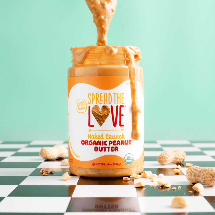 
                  
                    Load image into Gallery viewer, Spread The Love Naked Crunch Peanut Butter Jar with spoon drizzling peanut butter into jar
                  
                