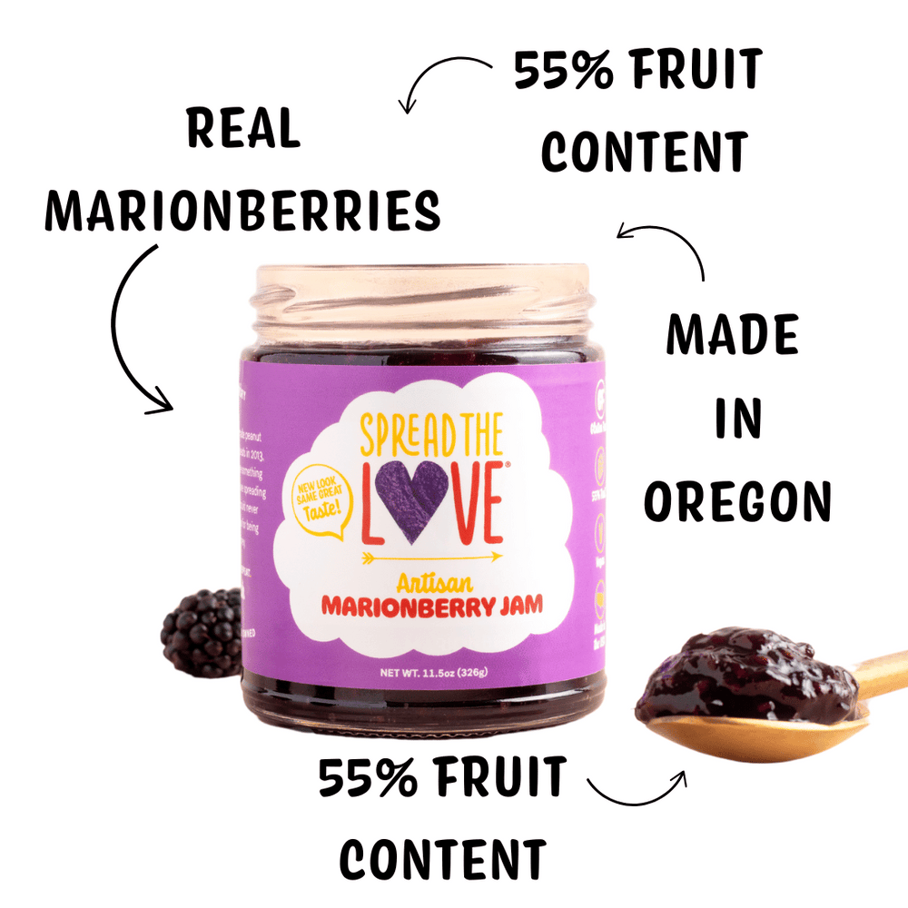 Spread The Love Marionberry Artisan Jam on counter with berries surrounding and spoonful of jam