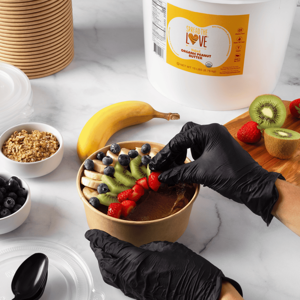 
                  
                    Load image into Gallery viewer, Person preparing smoothie bowl next to Spread The Love Peanut Butter Pail
                  
                