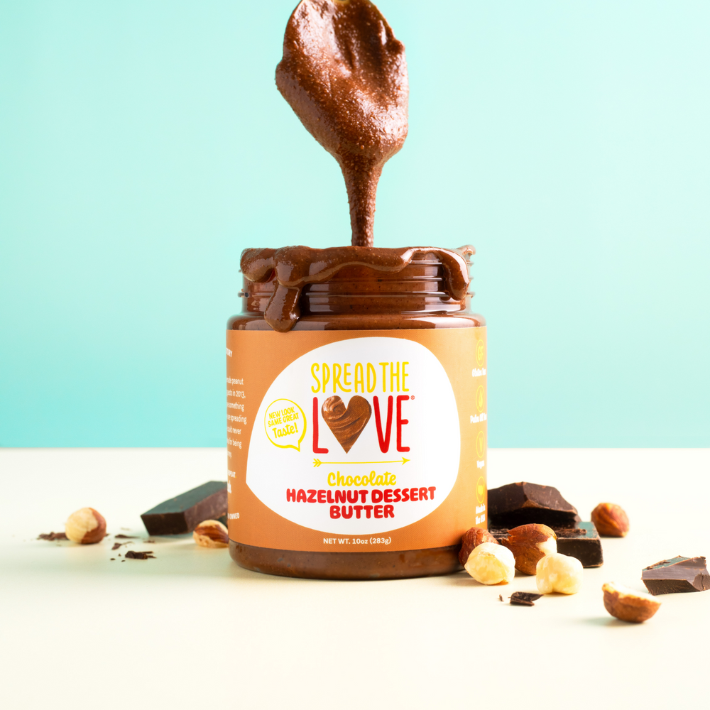 
                  
                    Load image into Gallery viewer, Spread The Love Chocolate Hazelnut Dessert Butter Jar with spoon drizzling into the jar. 
                  
                